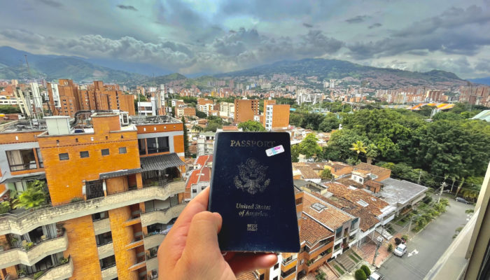 passport against medellin city backdrop