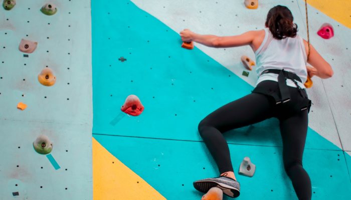 A woman climbing a blur wall